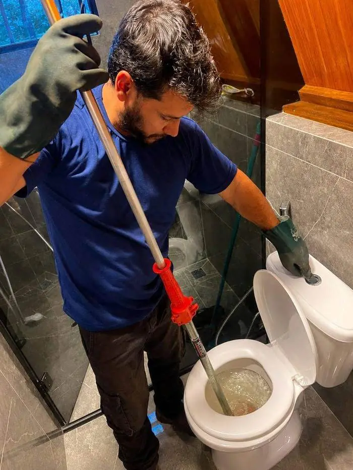 Profissional da Desentupidora Hidropró desentupindo vaso sanitário